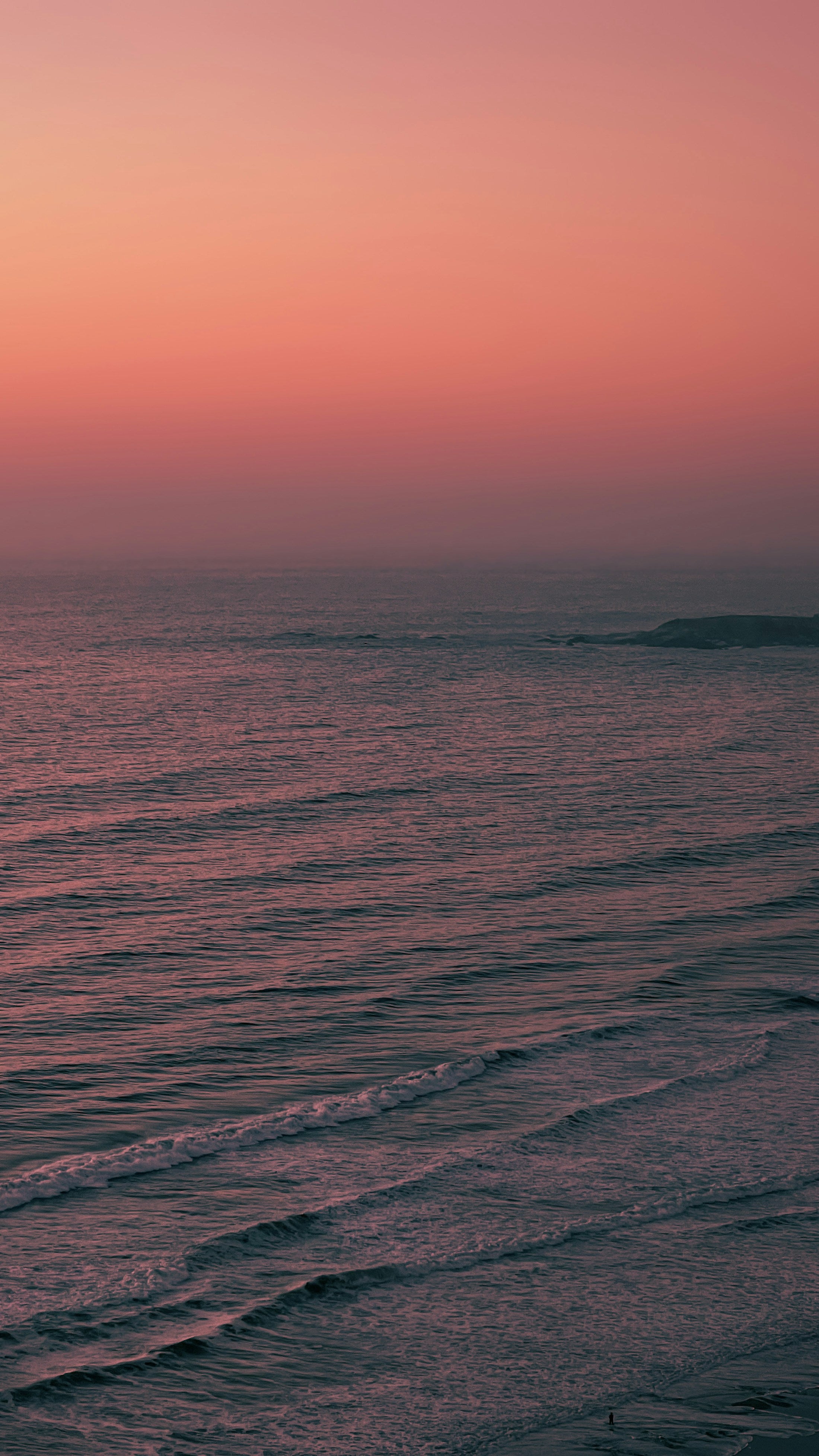Ocean beneath a pink sunset sky