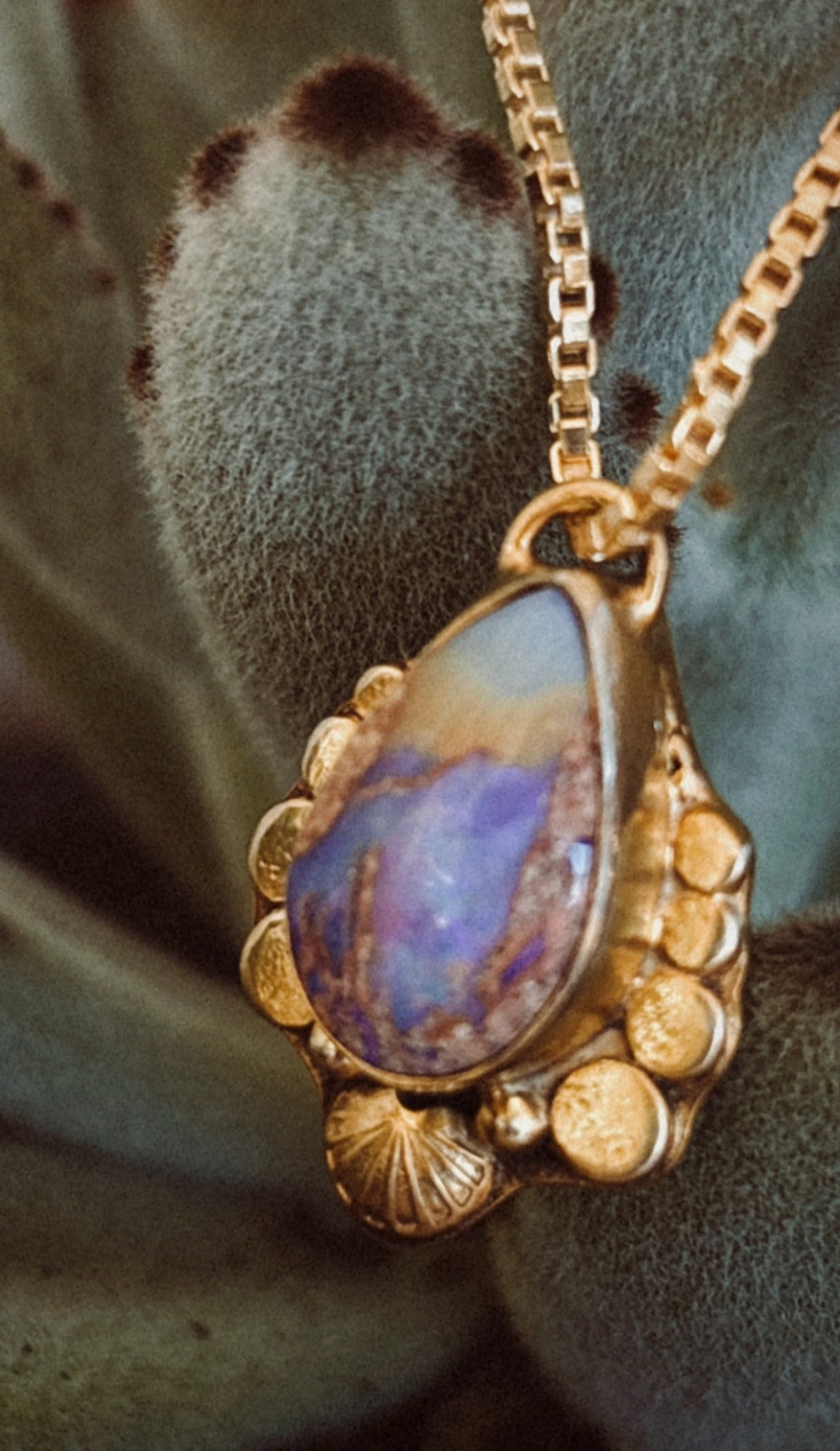 Handmade opal pendant among cactus leaves